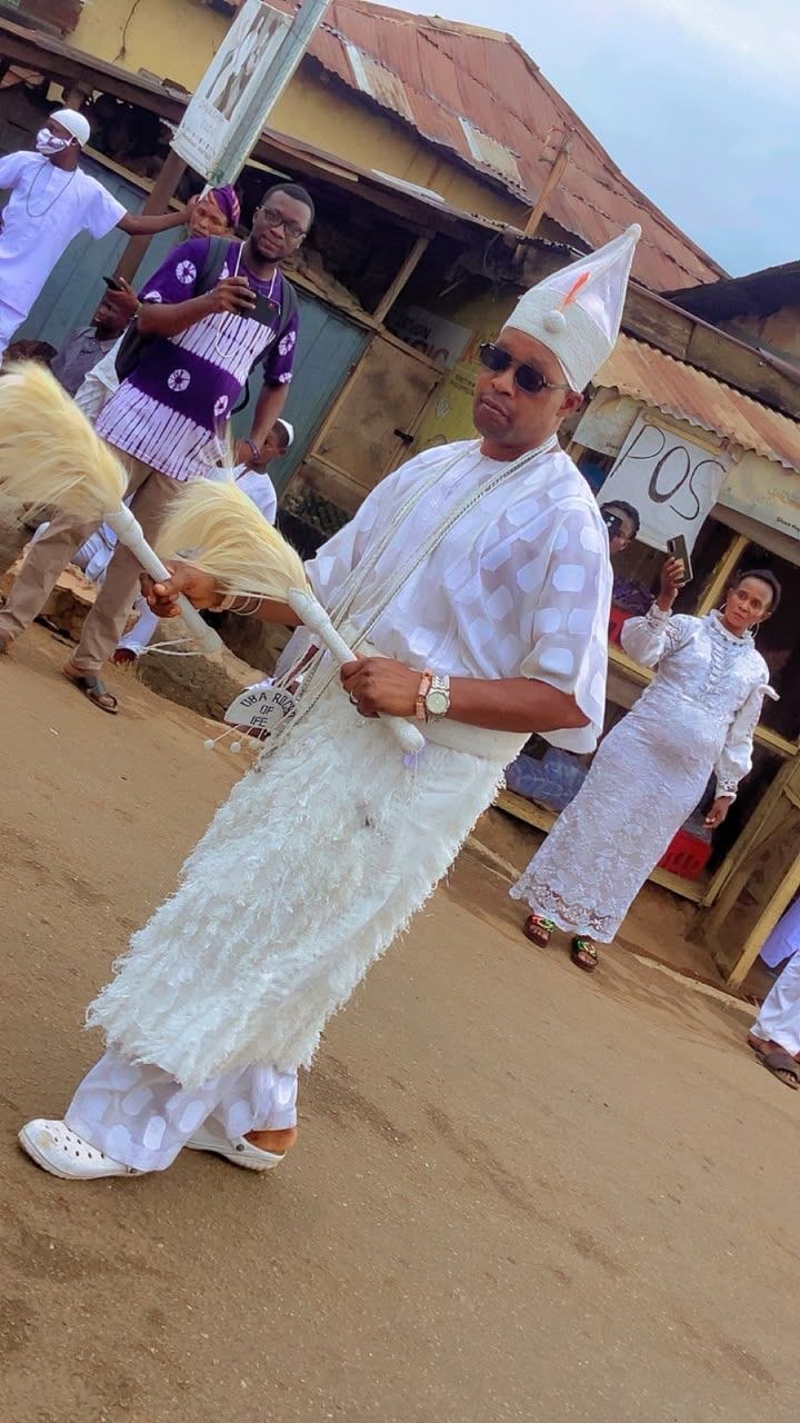 Dancer in white ceremonial attire in the procession